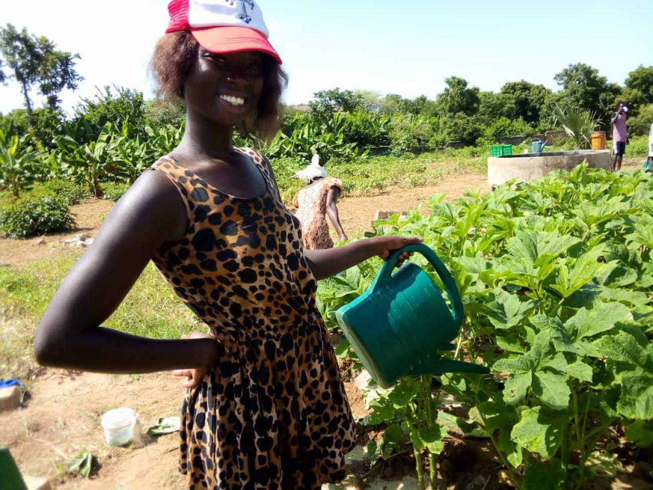 jeune agripreneuse arrosant son champ